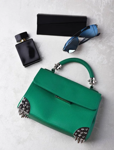 Kleine dames lederen groene tas met zonnebril, parfum en case — Stockfoto
