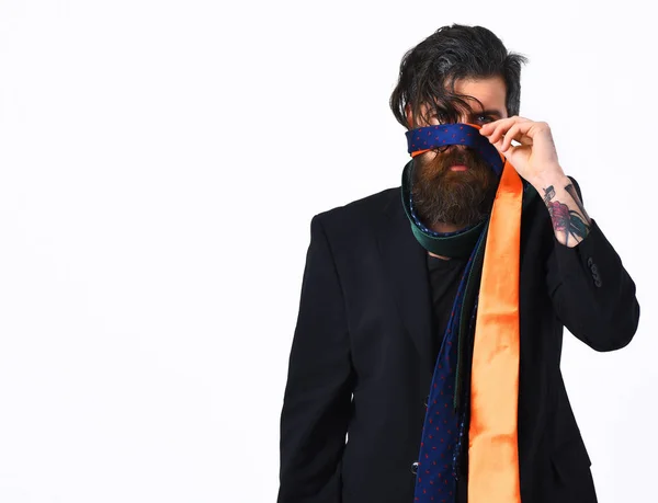 Brutal caucasiano hipster em terno preto segurando laços em torno da cabeça — Fotografia de Stock