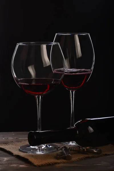 Verres à vin avec bouteille, tire-bouchon sur table en bois avec serviette en tissu sac — Photo