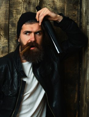 Sakallı, Kafkas hippisi elinde şişe, puro içiyor.