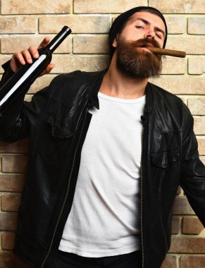 Sakallı, Kafkas hippisi elinde şişe, puro içiyor.