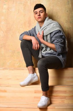 Gri süveter ve eşarplı yakışıklı genç adam.