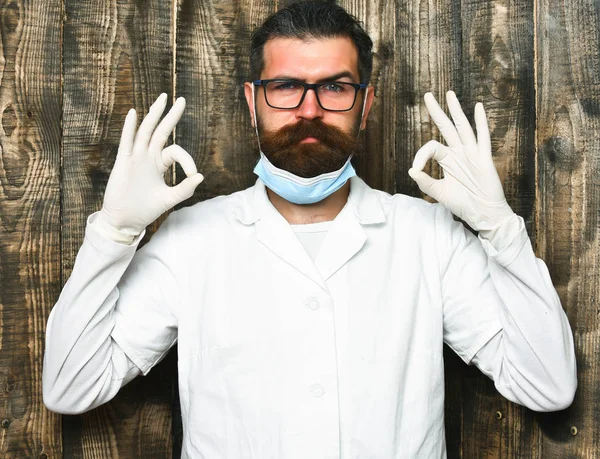 Bearded brutal caucasian doctor or postgraduate student in gloves