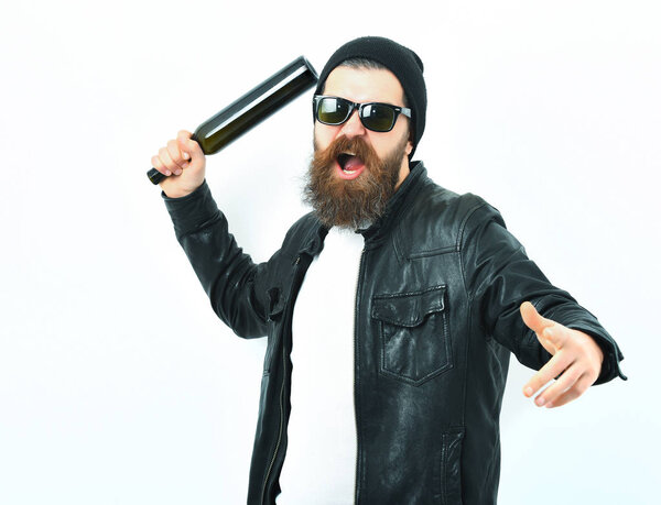 Bearded brutal caucasian hipster holding bottle