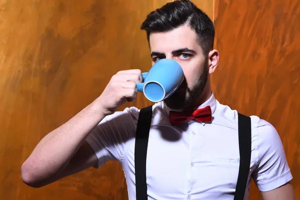 Homem barbudo bebendo de xícara de chá com rosto sério — Fotografia de Stock