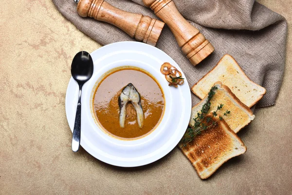 Kräm soppa brun färg med fisk, toast, pepperbox, timjan, saltkar — Stockfoto