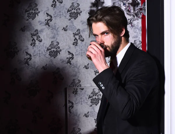 Skäggig man, affärsman i kostym, röd slips håller whisky glas — Stockfoto
