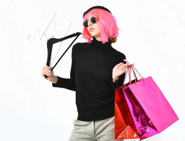 Fashionabla sexig tjej i rosa peruk innehav paket med hängare — Stockfoto