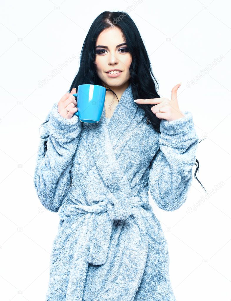 sexy girl posing in blue velour bathrobe with cup