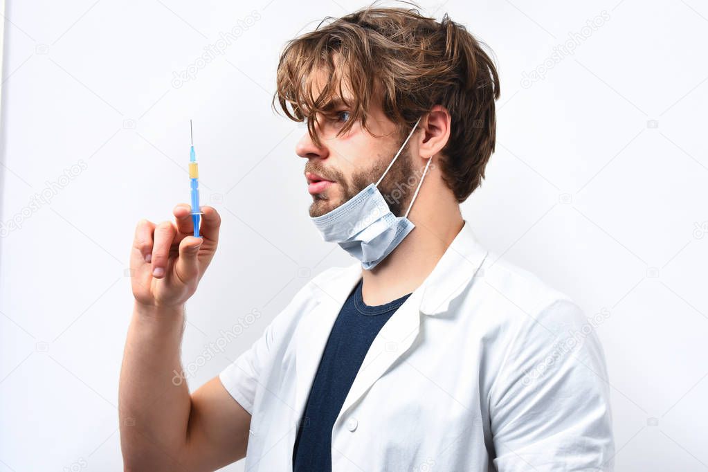 Bearded caucasian doctor or postgraduate student with syringe in mask