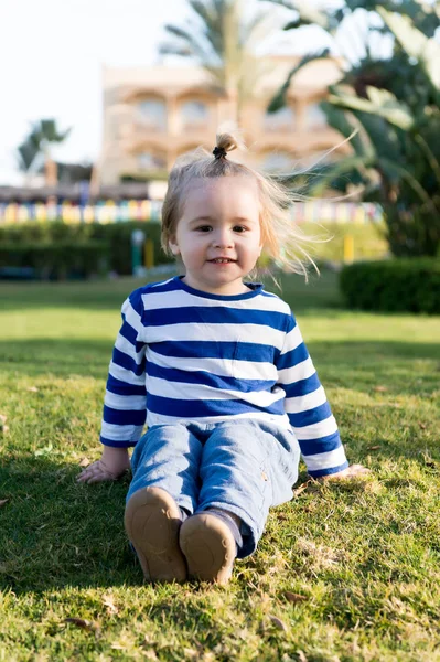 Pequeño bebé con la cara feliz en la hierba verde descalzo —  Fotos de Stock