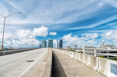 karayolu üzerinde mavi bulutlu gökyüzü gökdelenler ile