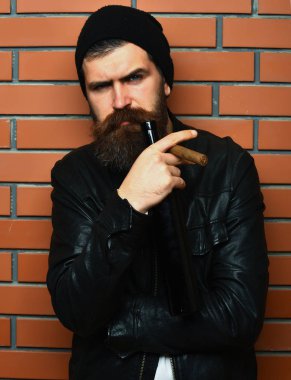 Sakallı, Kafkas hippisi elinde şişe, puro içiyor.