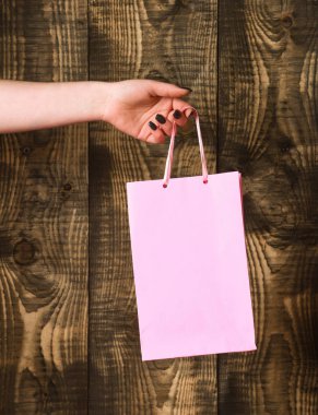 ahşap arka plan üzerinde kadın elinde pembe alışveriş çantası