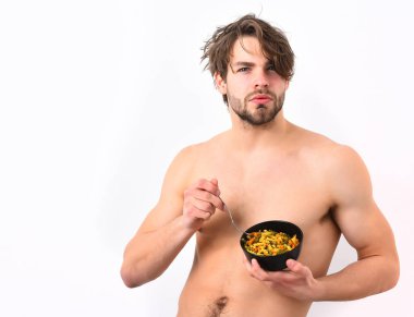 Kafkas seksi genç maço elinde makarna ile siyah kase tutuyor.