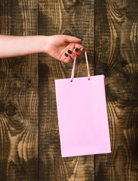 Bolso Cabás rosa en mano femenina sobre fondo de madera — Foto de Stock