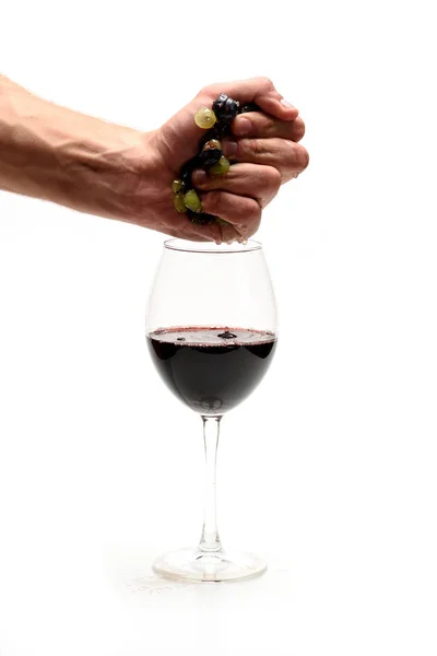 Forte mão masculina espremendo vinho de uvas para vidro — Fotografia de Stock