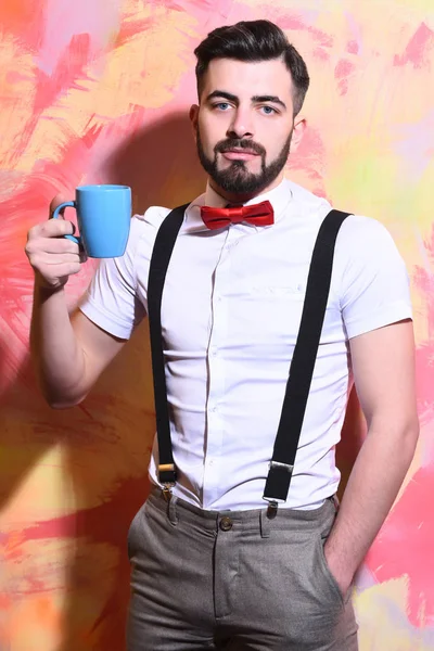 Uomo barbuto in possesso di una tazza di tè, caffè con viso serio — Foto Stock
