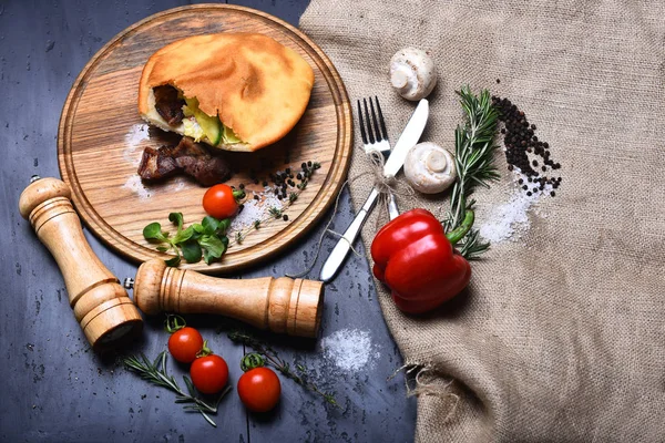 Calzone or pie with vegetables, pepperbox and saltcellar on tray — Stock Photo, Image