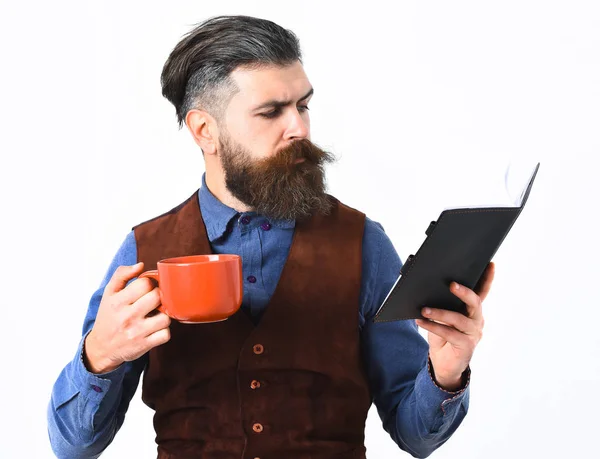 Barbudo hombre leyendo bloc de notas, taza de té con cara seria —  Fotos de Stock