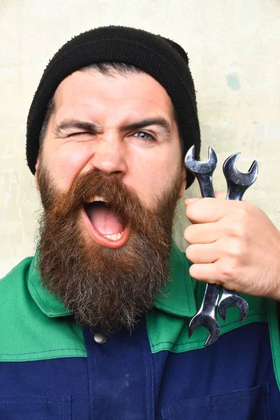 Vousatý brutální bělošský mechanik držící kovové klíče — Stock fotografie
