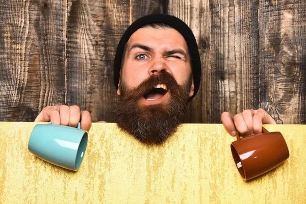 Barbudo brutal hipster caucásico con hoja de papel y tazas — Foto de Stock