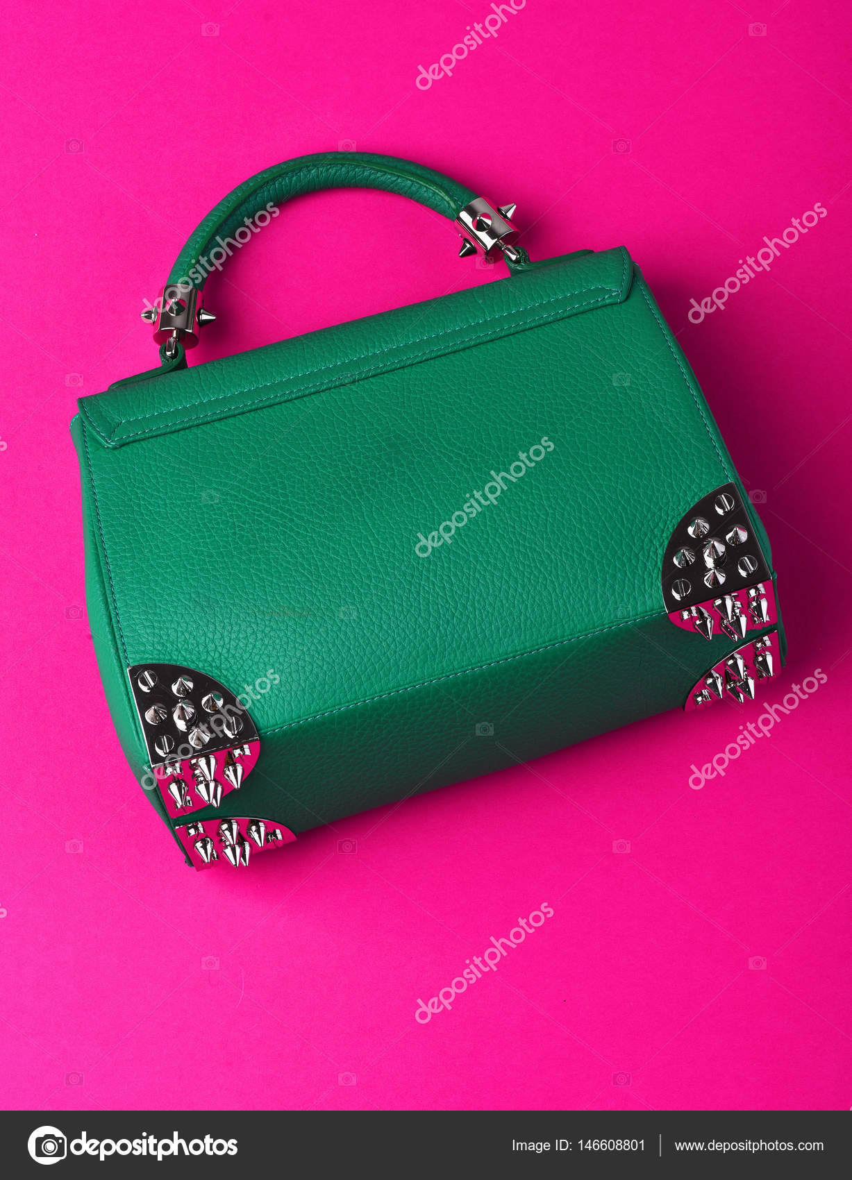 Small womans leather green bag with metallic spikes on pink Stock Photo by  ©stetsik 146608801