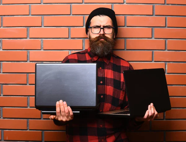 Bearded brutal caucasian hipster holding laptops — Stock Photo, Image