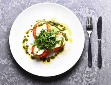 Dilimlenmiş lezzetli domates mozarella peyniri ve yeşil Roka Salatası ile