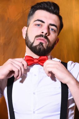 Stüdyo duvarında ciddi bir yüzü olan sakallı bir adam.