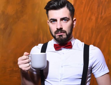 Elinde çay tutan sakallı adam, ciddi yüzlü kahve.