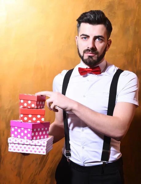 Бородатый мужчина держит коробки с серьезным лицом — стоковое фото