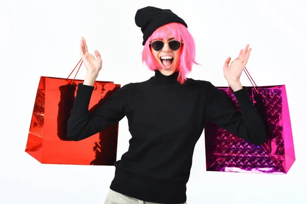 Fashionabla sexig tjej i rosa peruk innehav paket eller väskor — Stockfoto