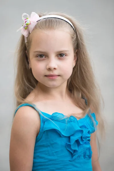 Niña pequeña con cara adorable en chaleco azul al aire libre —  Fotos de Stock