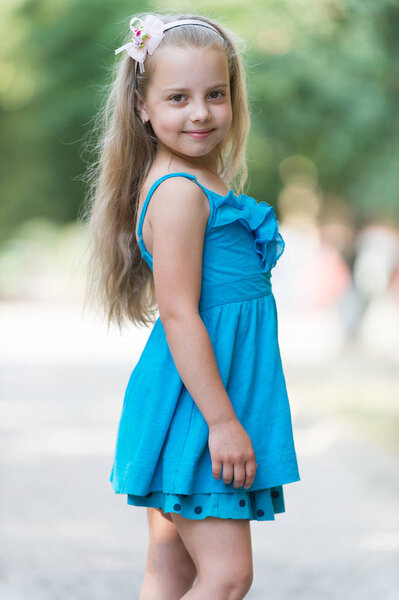 small baby girl with smiling face in blue dress outdoor