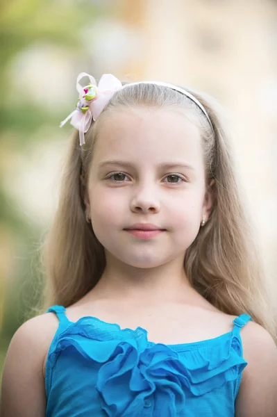 Niña pequeña con la cara sonriente en chaleco azul al aire libre —  Fotos de Stock