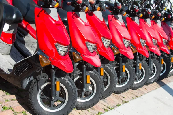 Röd skotrar eller motorcyklar till försäljning eller uthyrning i rad — Stockfoto