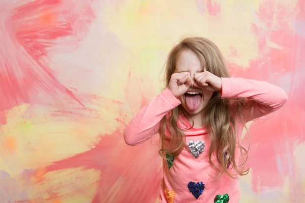 Piccola bambina felice in camicia rosa mostrando la lingua — Foto Stock