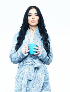 Mavi kadife bornozla fincanla poz veren seksi kız.