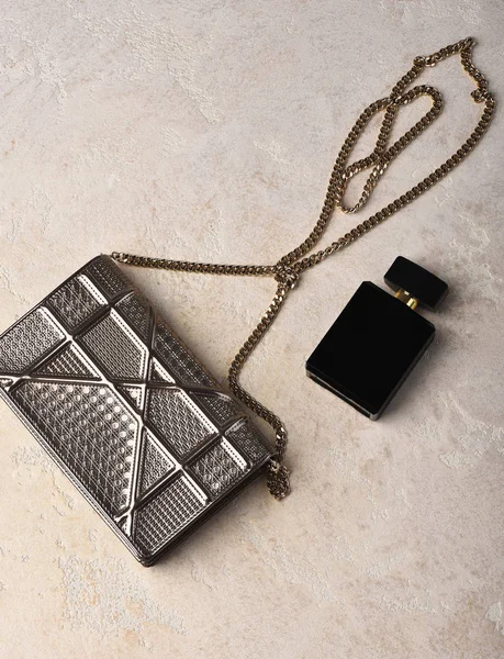 Mulheres pequenas saco de prata metalizado com corrente metálica perto de perfume — Fotografia de Stock
