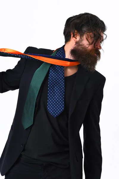 Brutal caucasiano hipster em terno preto segurando laços em torno do pescoço — Fotografia de Stock
