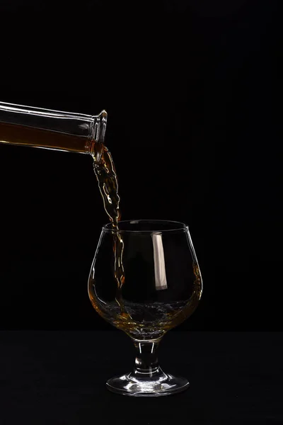 Vidro, garrafa com conhaque ou uísque isolado sobre fundo preto — Fotografia de Stock