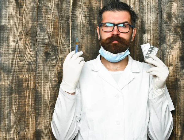 Brutalny lekarz kaukaski z brodą lub student podyplomowy trzymający pigułki — Zdjęcie stockowe