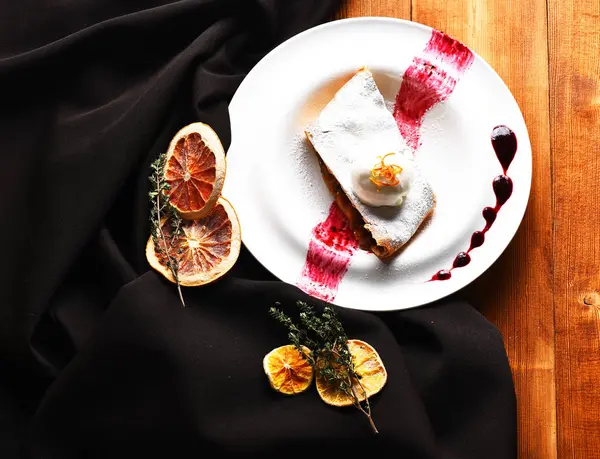 Delicious apple strudel with vanilla ice cream and berry sauce — Stock Photo, Image