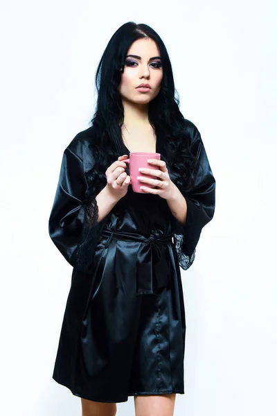 Siyah ipek elbiseyle fincanla poz veren seksi kız — Stok fotoğraf