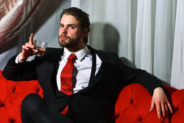 Homem barbudo, homem de negócios segurando copo de uísque em gravata vermelha — Fotografia de Stock
