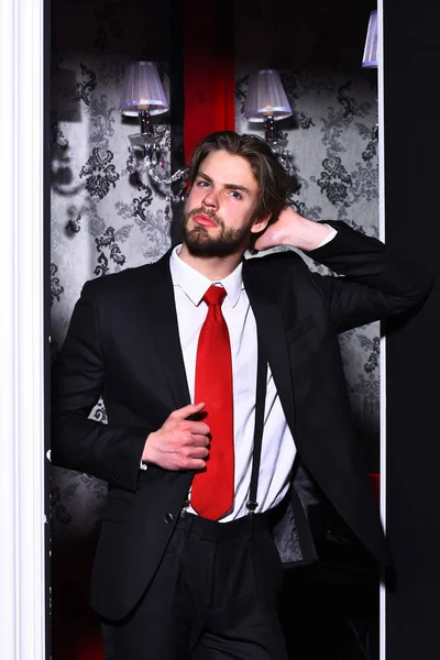 Бородатий чоловік, бізнесмен в костюмі і червона краватка проти шпалер — стокове фото