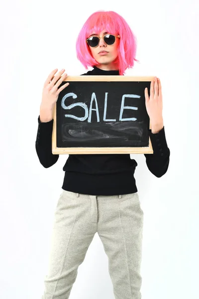 头戴假发的时髦女孩，手持刻有销售字样的木板 — 图库照片