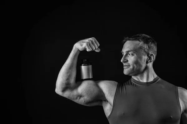 Knappe bodybuilder man met gespierd lichaam houdt pot van de pil, steroïden — Stockfoto