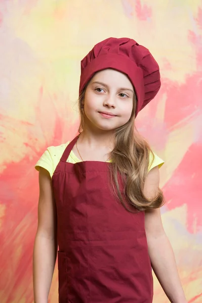 작은 여자 요리사 모자와 앞치마에 행복 한 얼굴로 — 스톡 사진